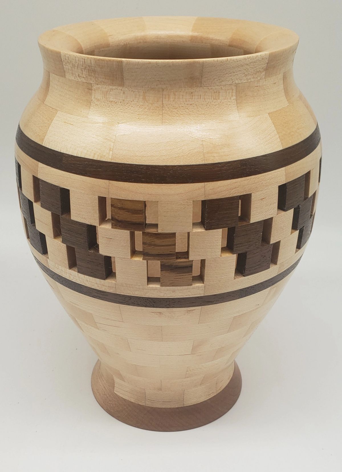 A pale maple seed jar with a band of open segments, where dark walnut and light blocks are spaced with visible gaps between them