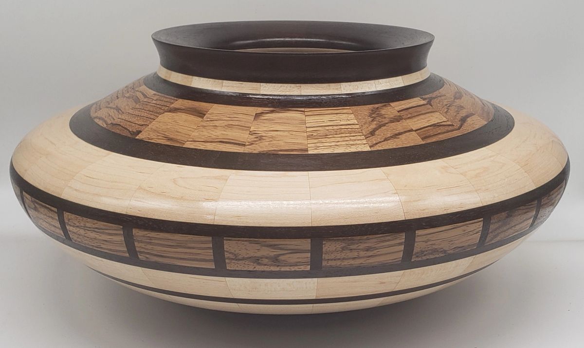 A low wide Sikyatki-form wooden vessel in pale maple and striped zebrawood with dark banding and a narrow opening